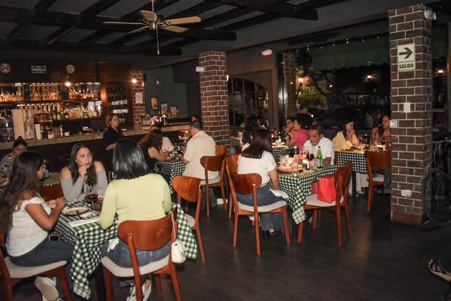 El salón de Tarantella con manteles verdes a cuadros y columnas de ladrillo